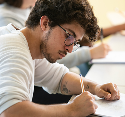 A male student writing in class at St. 蜜桃視頻_蜜桃視頻APP_蜜桃視頻官网